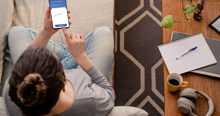 image of a woman sitting on a couch looking at her phone