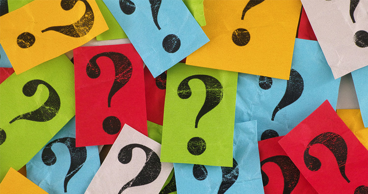 A pile of various colored paper with question marks printed on them